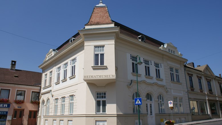 Heimatmuseum Mank, © Stadtgemeinde Mank Ein historisches Gebäude mit der Aufschrift 'Heimatmuseum' in Mank, Österreich, bei klarem Himmel.