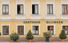 Gasthaus in St. Peter in der Au, © Niederösterreich Werbung/Daniela Führer Fassade eines gelben Gasthauses mit der Aufschrift 'Gasthaus Ellinger'.