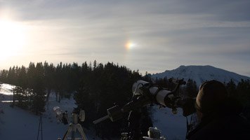 Ausblick von der Astrostation Hochbärneck, © Astrostation Teleskope auf einer verschneiten Berglandschaft mit Sonnenhalo.
