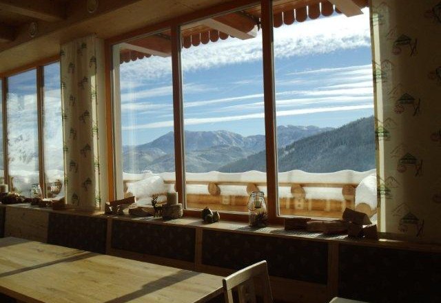 Höhensteinstube Familie Helmel, © Fam. Helmel Blick aus einem Fenster auf verschneite Berge und blauen Himmel.