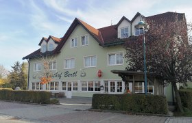 Gasthof Bertl, © Roman Zöchlinger Ein zweistöckiges Gebäude mit der Aufschrift 'Gasthof Bertl', umgeben von Bäumen und Sträuchern.