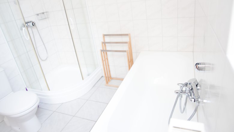Bad, Gästezimmer Aprico, © Aprico Helles Badezimmer mit Dusche, Badewanne und Handtuchhalter.