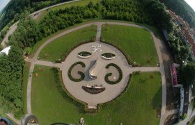 Garten des Schloss Kreisbach, © zVg Schloss Kreisbach Luftaufnahme eines Gartens mit Gesichtsmuster aus Pflanzen und Wegen.