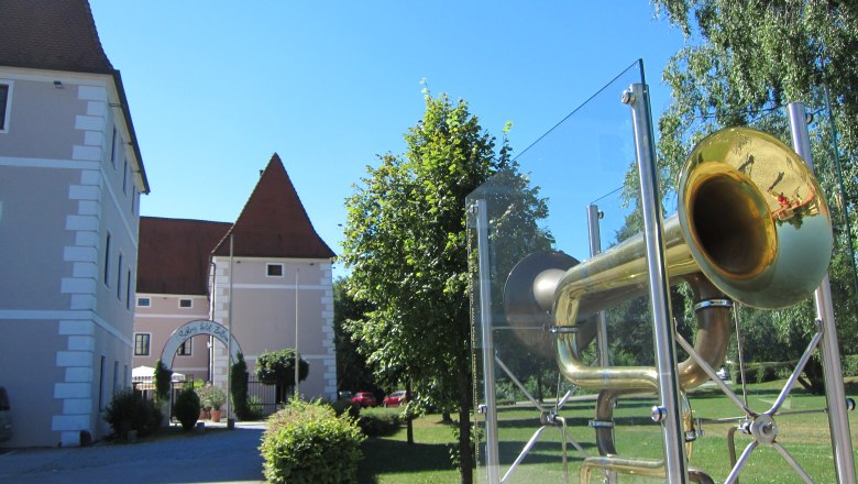 Gemeinde Zeillern, © zVg Gemeinde Zeillern Schloss Zeillern mit einer großen Trompete im Vordergrund.