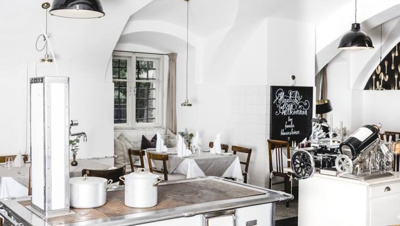 Helles Interieur sorgt für Gemütlichkeit, © Niederösterreich Werbung/David Schreiber Helles Restaurantinterieur mit weißen Wänden, Holzmöbeln und einem alten Herd.