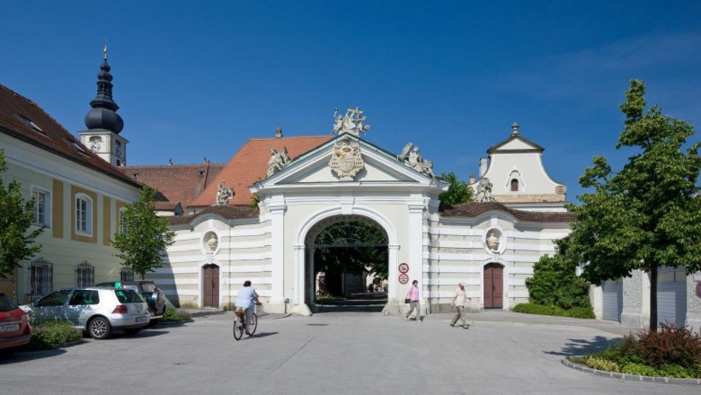 Bishopric building, © Werner Jäger Historic diocese building with archway and church tower in the background.