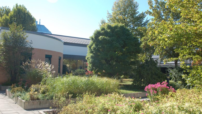 Garten Bildungshaus St.Hippolyt, © Bildungshaus St.Hippolyt Garten des Bildungshauses St. Hippolyt mit Pflanzen und Bäumen vor einem modernen Gebäude.