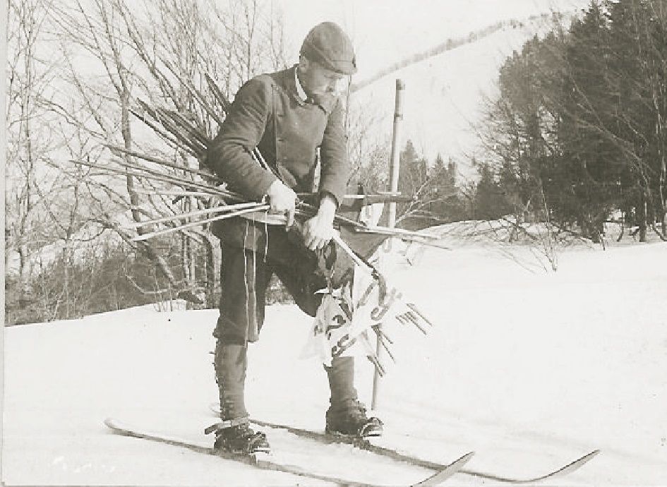Historische Aufnahme eines Mannes auf Skiern mit Skistöcken im Schnee.