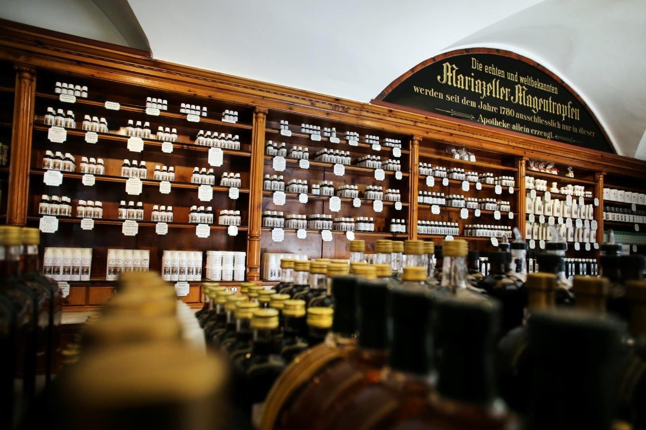 Innenansicht einer traditionellen Apotheke mit Regalen voller Flaschen und Gläser.