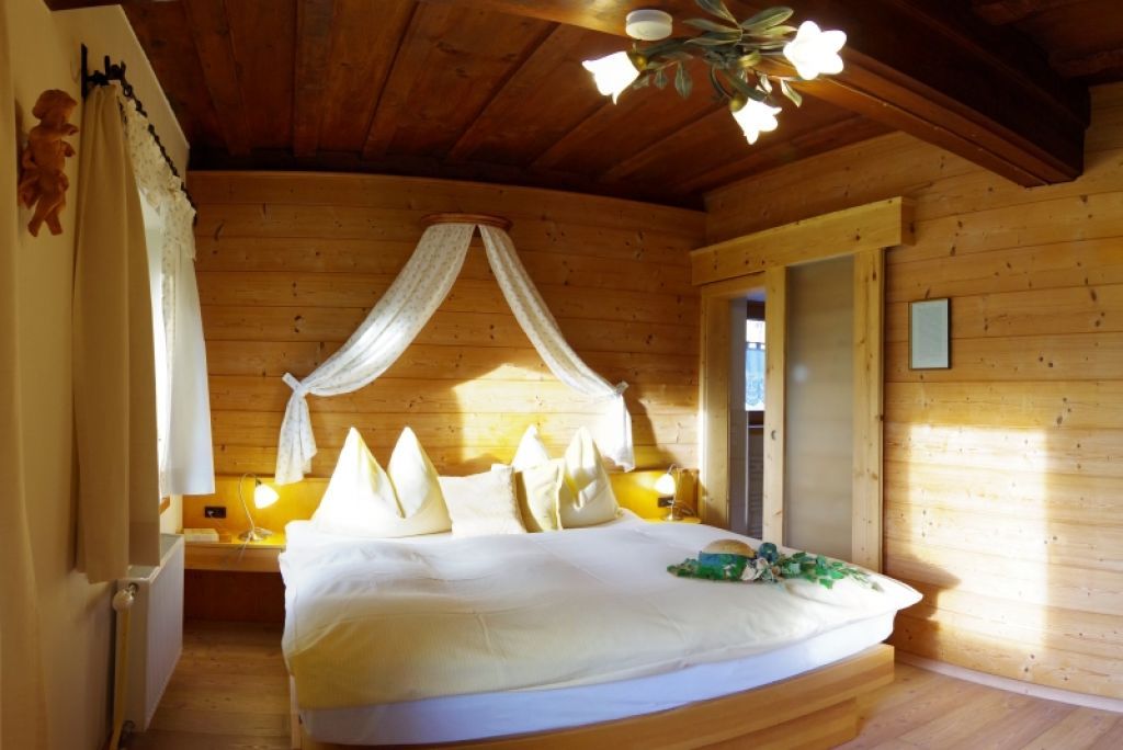 Gemütliches Schlafzimmer mit Holzwänden und Doppelbett.