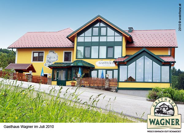 Gasthaus Wagner in Allhartsberg mit gelber Fassade und roten Dächern.