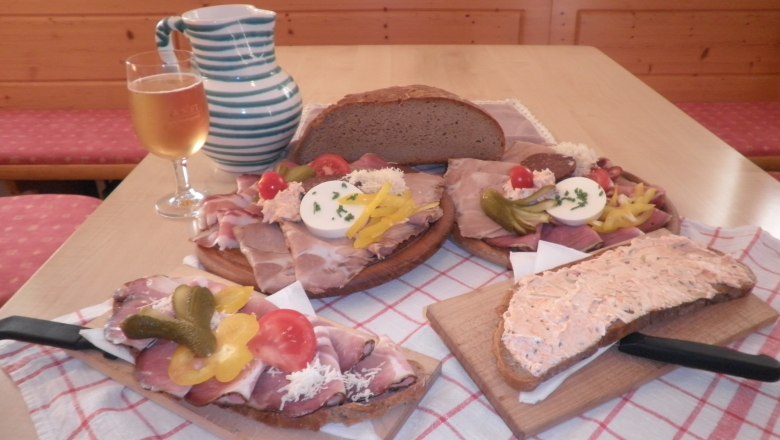 Traditionelle österreichische Jause mit Brot, Aufschnitt und Getränk.