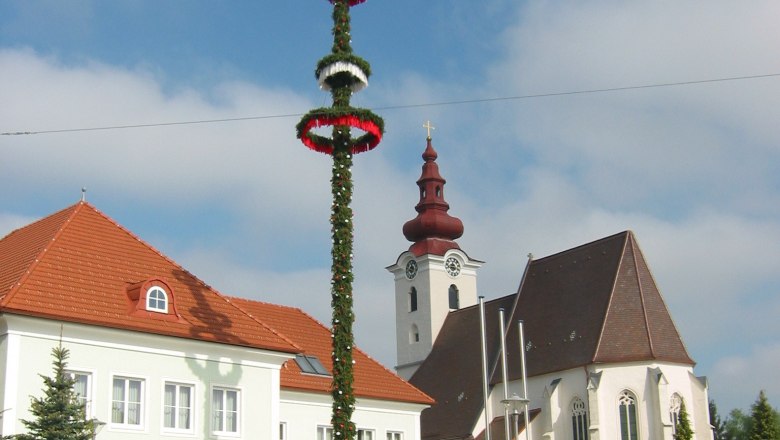 Kirche mit Zwiebelturm und Maibaum in St. Pantaleon-Erla.