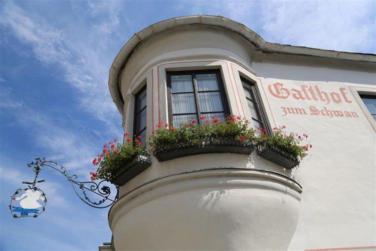 Fassade des Gasthofs zum Schwan mit Erker und Blumenkästen.