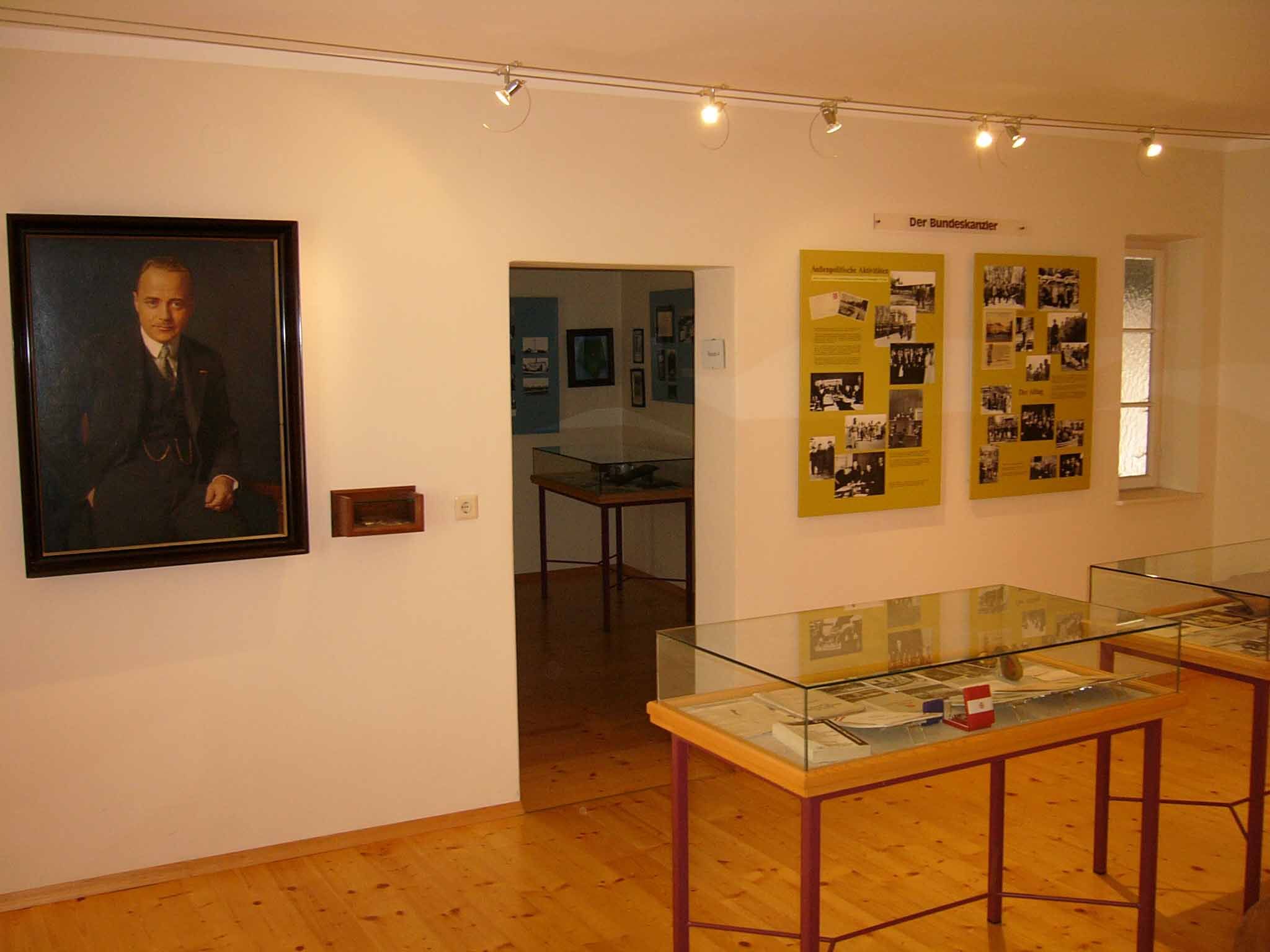 Innenansicht eines Museums mit Porträt und Ausstellungstafeln.