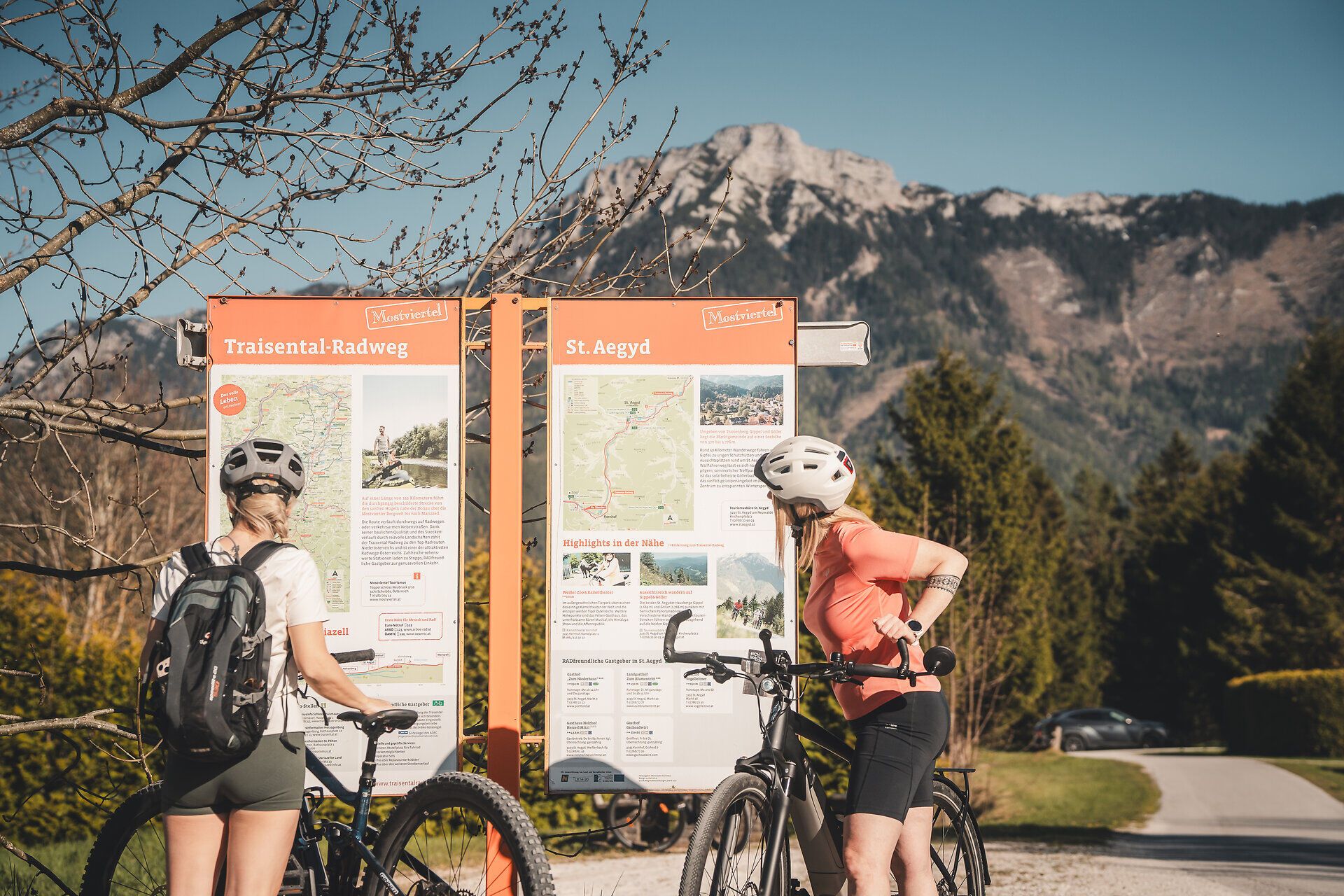 Radfahrerinnen betrachten Schilder.