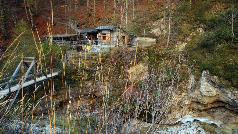Wooden hut in the Ötschergräben with bridge and autumnal landscape.