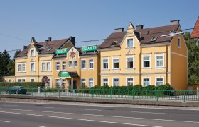 Gelbes Gebäude der Pension Elisabeth mit grünen Schildern.