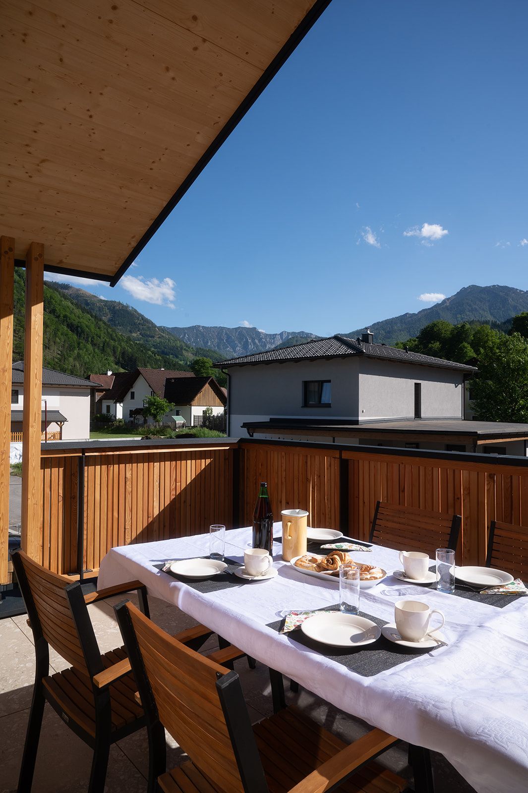 Ein gedeckter Tisch auf einer Terrasse mit Bergblick.