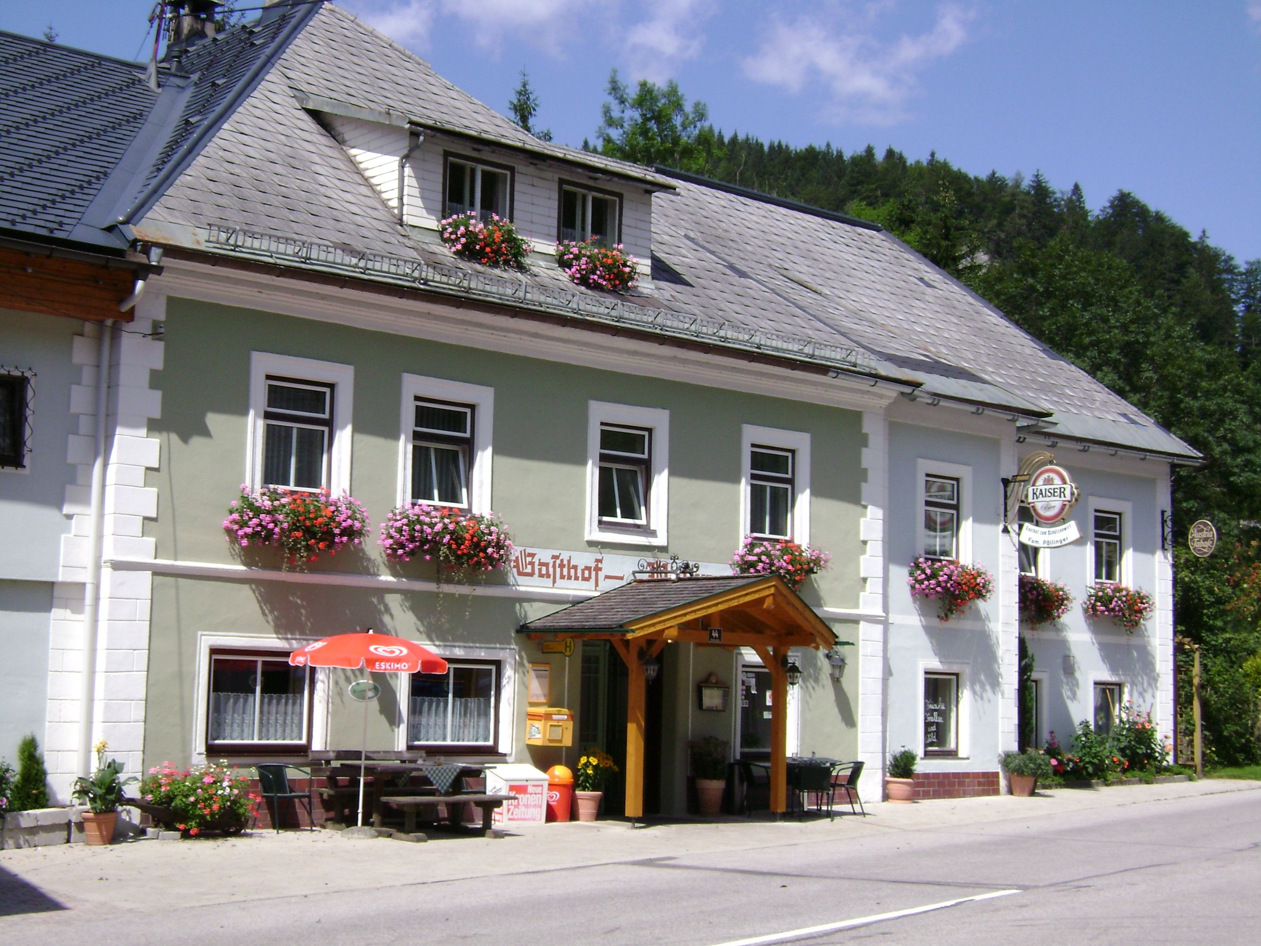 Traditionelles Gasthaus mit Blumenkästen und Kaiser-Bierschild.