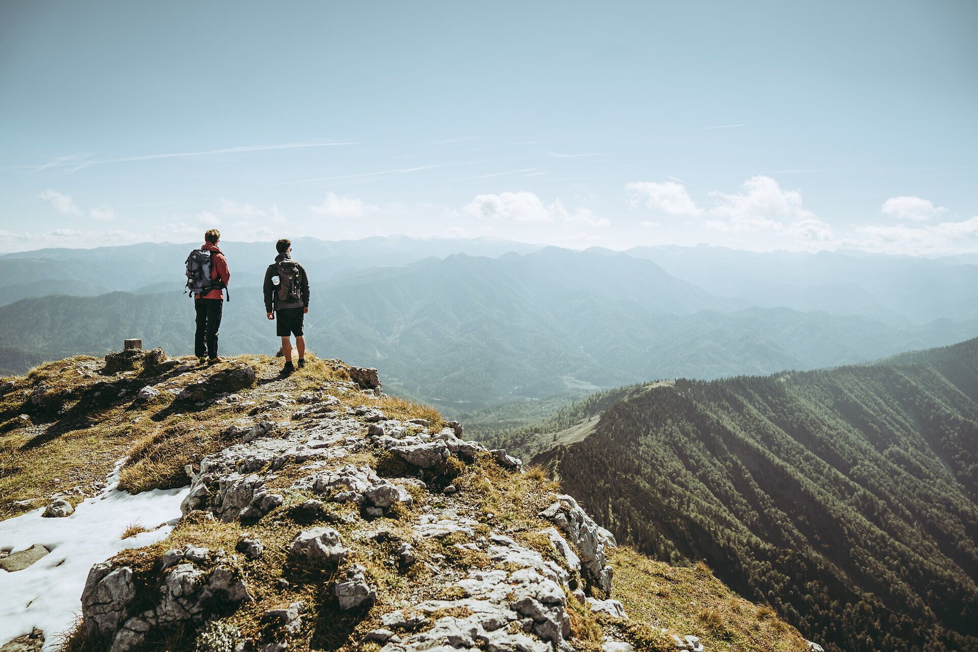 Zwei Wanderer stehen am Gipfel und genießen den atemberaubenden Blick über die Ybbstaler Alpen. Die frische Bergluft und die majestätischen Landschaften laden dazu ein, die Seele baumeln zu lassen und die Schönheit der Natur zu erleben.
