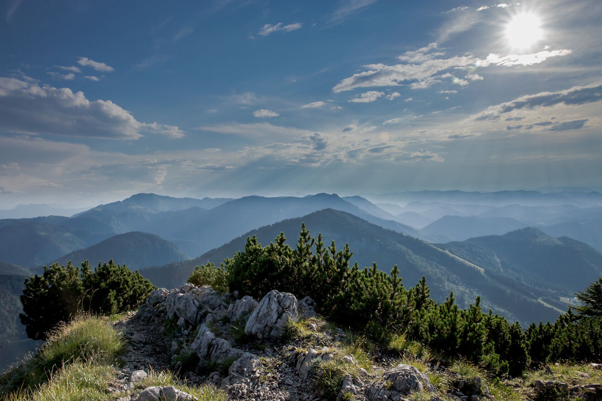 Die majestätischen Berge erheben sich in sanften Wellen, während die Sonne sanft über die Gipfel strahlt. Ein Gefühl von Freiheit und Abenteuer durchzieht die Luft, ideal für Wanderer, die die unberührte Natur und die atemberaubenden Ausblicke genießen möchten.