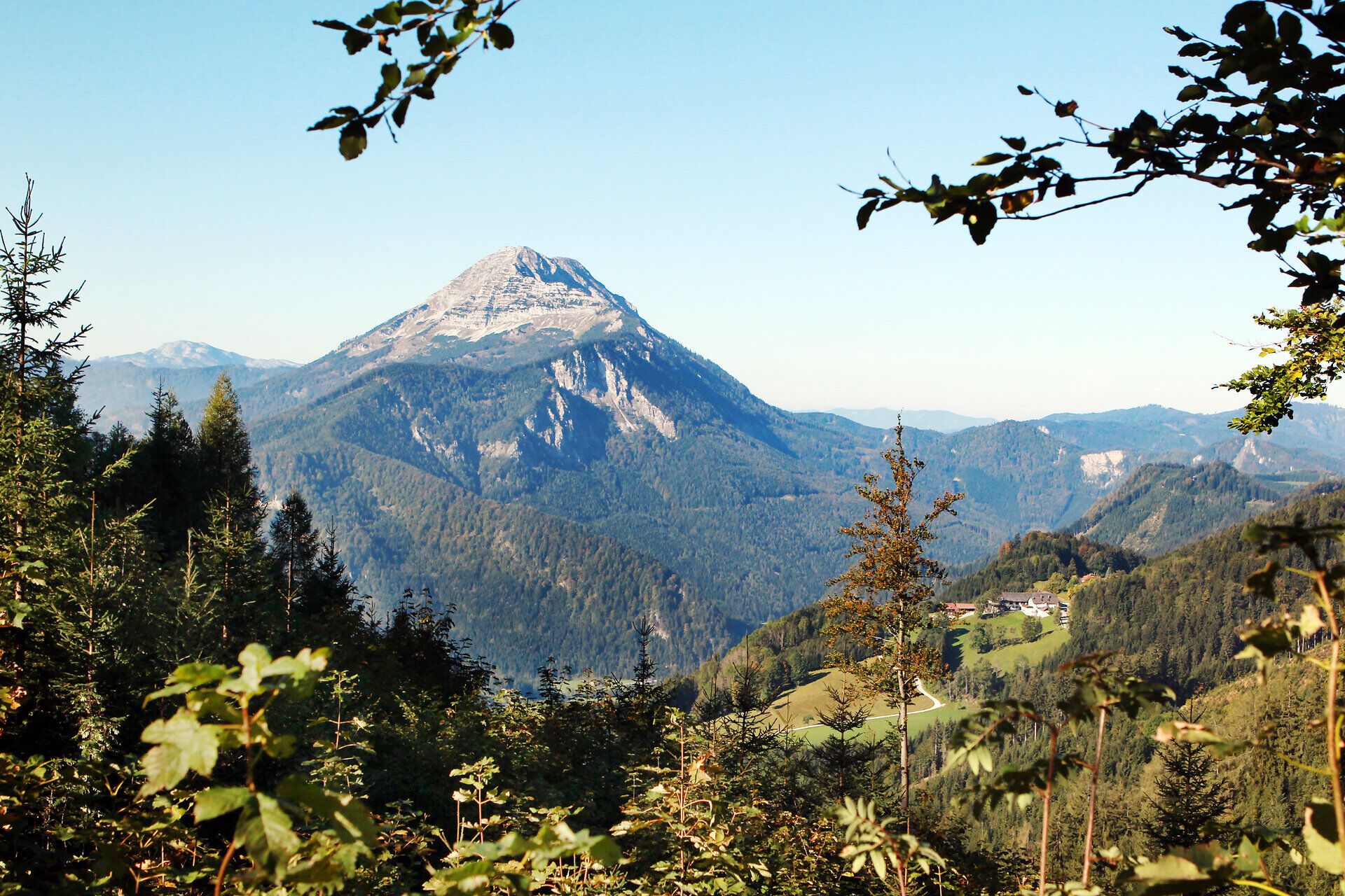 Die majestätischen Gipfel erheben sich stolz über die sanften Hügel, während die Sonne den Himmel in warmen Farben erleuchtet. Ein Gefühl von Freiheit und Abenteuer durchdringt die Luft, während Wanderer die atemberaubende Aussicht genießen und die Ruhe der Natur erleben.