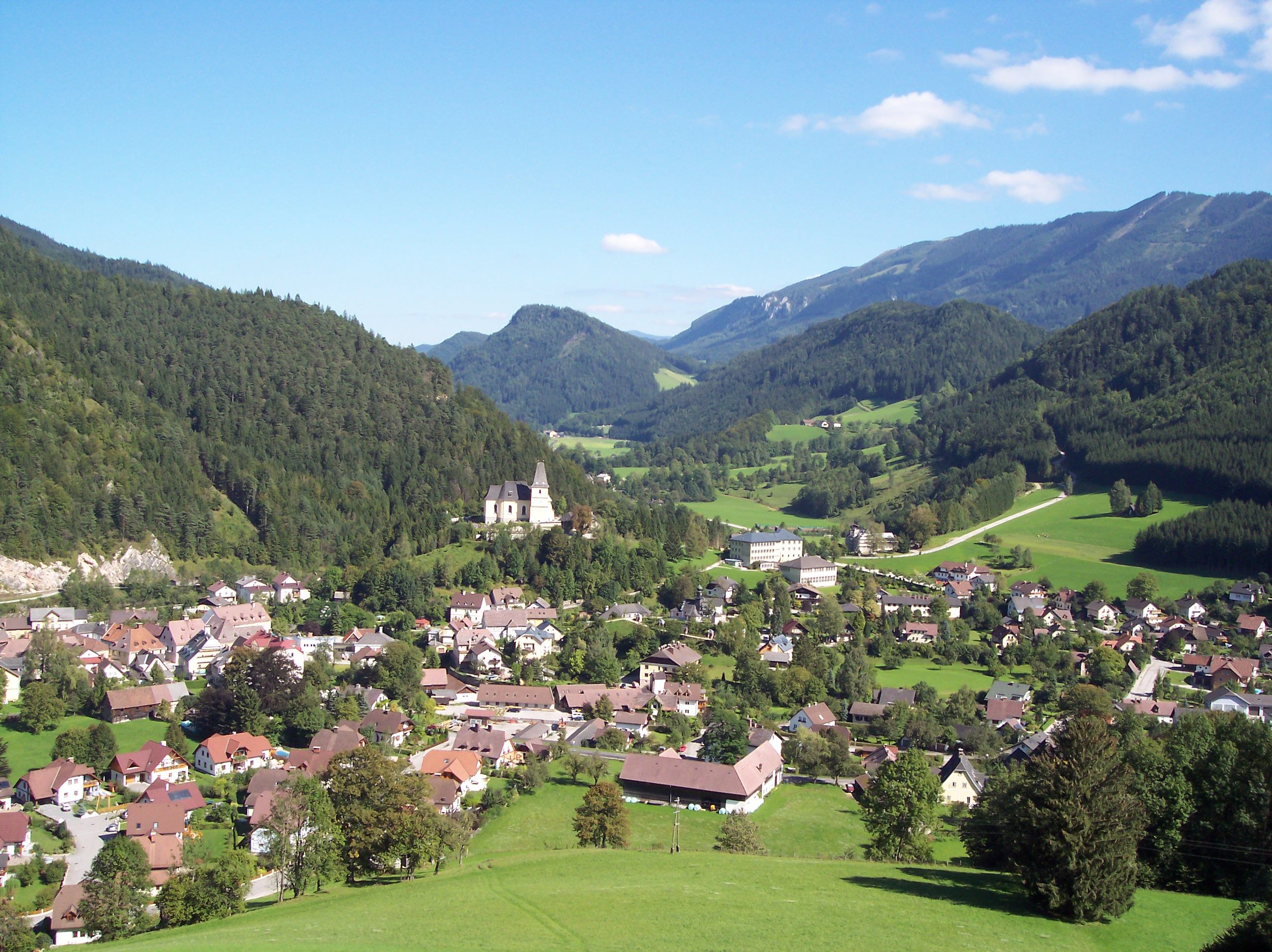 Panorama von Hollenstein an der Ybbs mit Kirche und Bergen im Hintergrund.