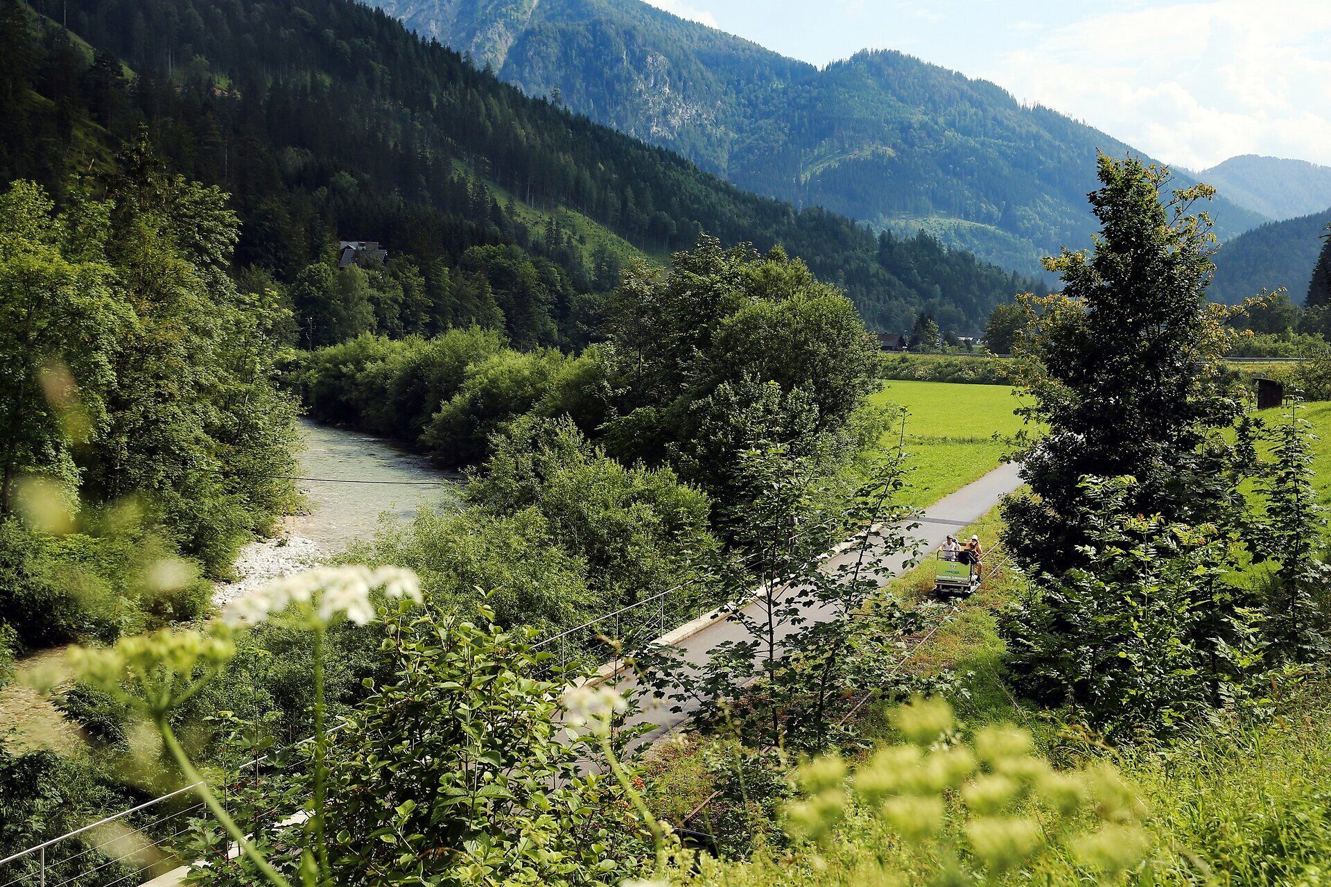 Umgeben von majestätischen Bergen und üppigem Grün, lädt die idyllische Landschaft zu unvergesslichen Erlebnissen ein. Der sanfte Fluss schlängelt sich durch die Natur und bietet eine perfekte Kulisse für entspannte Spaziergänge und Abenteuer in der frischen Luft.