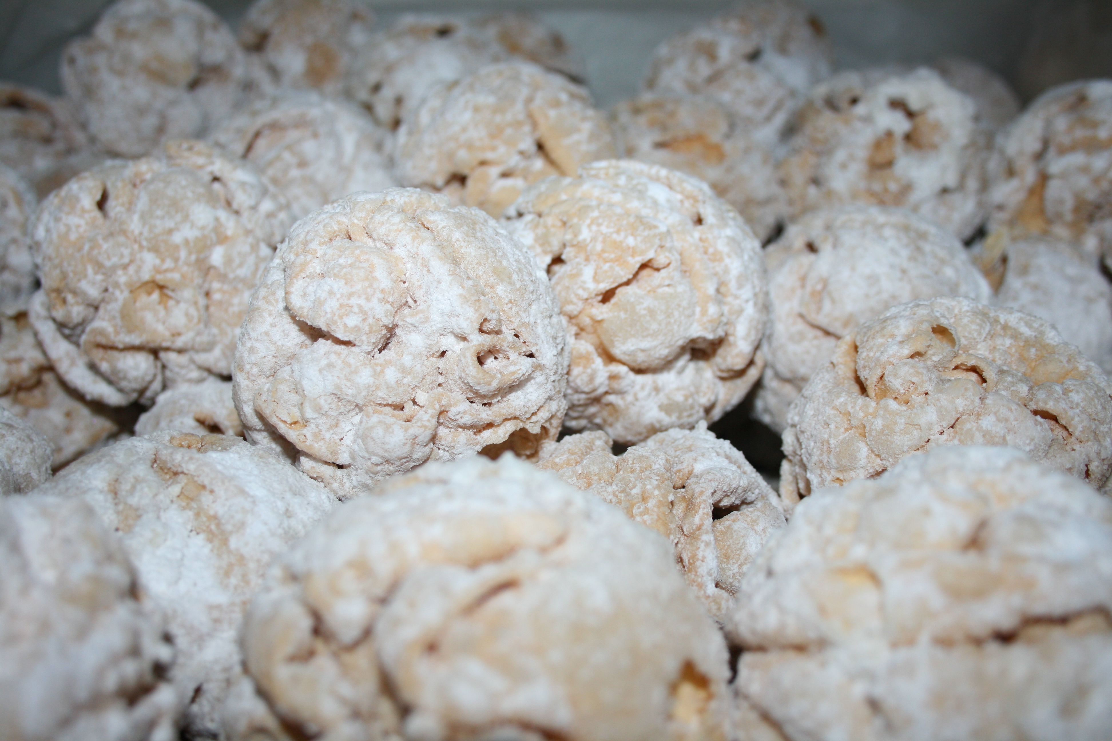 Nahaufnahme von mit Puderzucker bestäubten Gebäckkugeln.