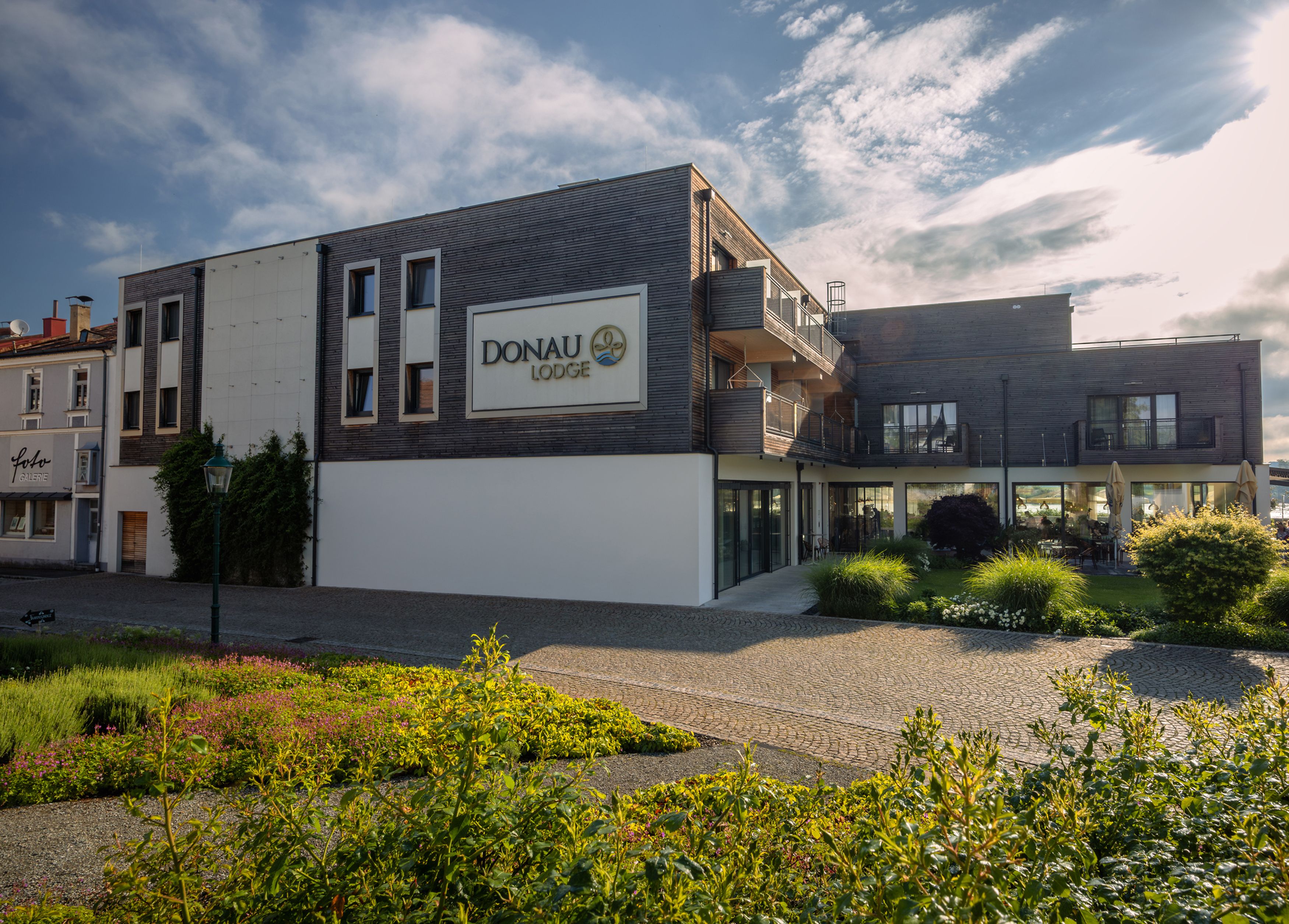 Außenansicht der Donau Lodge Ybbs mit moderner Architektur und Garten im Vordergrund.