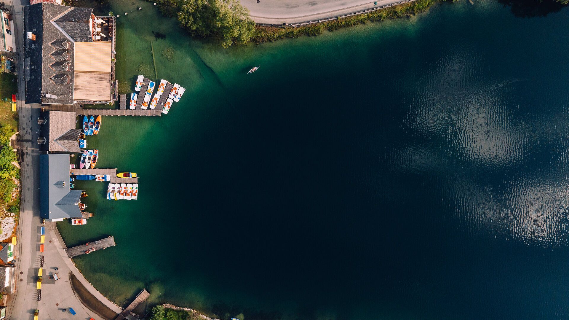 Luftaufnahme des Lunzer Sees mit Bootsanlegestellen, Stegen und dem klaren Wasser des Sees.