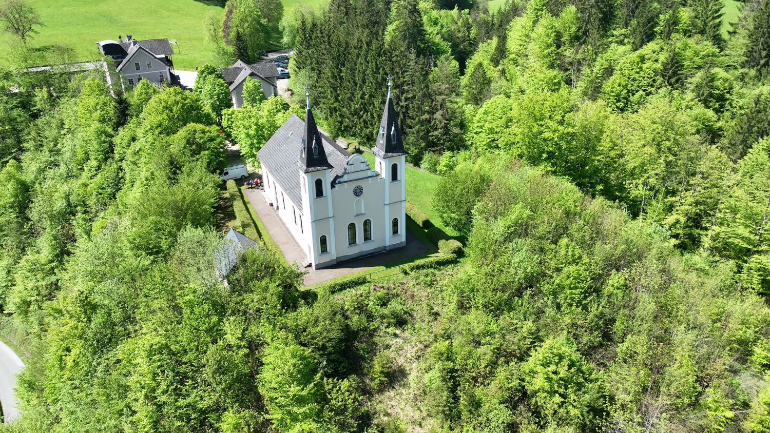 Luftaufnahme der Wallfahrtskirche Maria Seesal umgeben von grünen Bäumen und Wäldern.