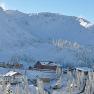 Winterlandschaft mit verschneiten Bergen und Gebäuden am Hochkar.