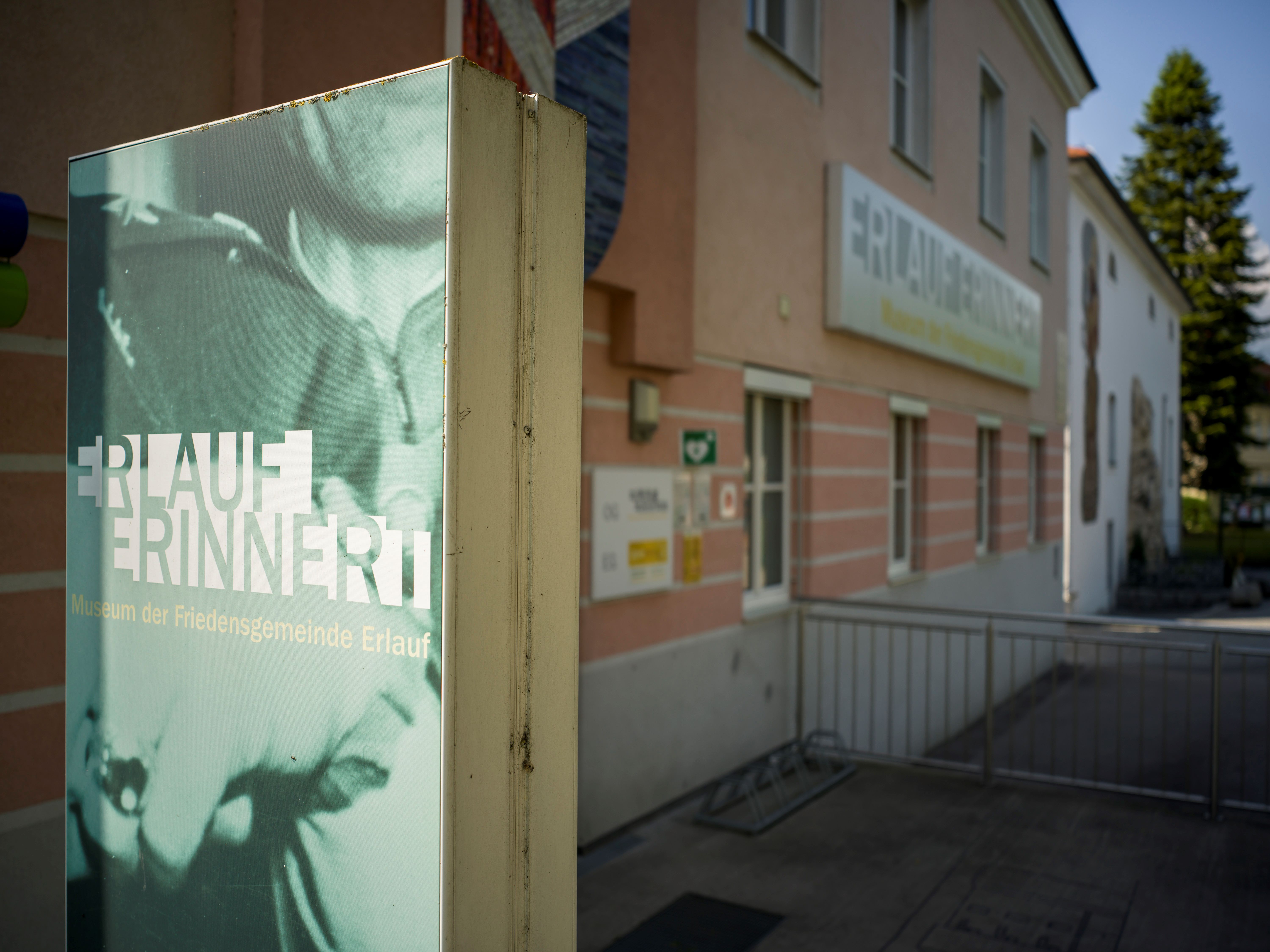 Außenansicht des Friedensmuseums Erlauf mit Schild 'Erlauf erinnert'.