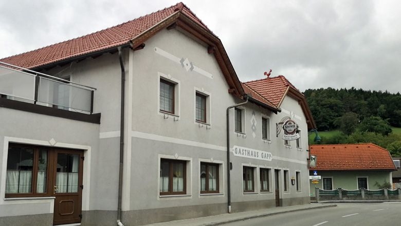 Gasthaus Gapp in Weinburg mit grauer Fassade und rotem Dach.