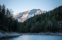 Die sanften Wellen des Erlaufstausees spiegeln die majestätischen Berge wider, während die winterliche Stille die Luft erfüllt. Umgeben von dichten Wäldern und schneebedeckten Gipfeln, lädt diese idyllische Landschaft zu einem unvergesslichen Naturerlebnis ein.