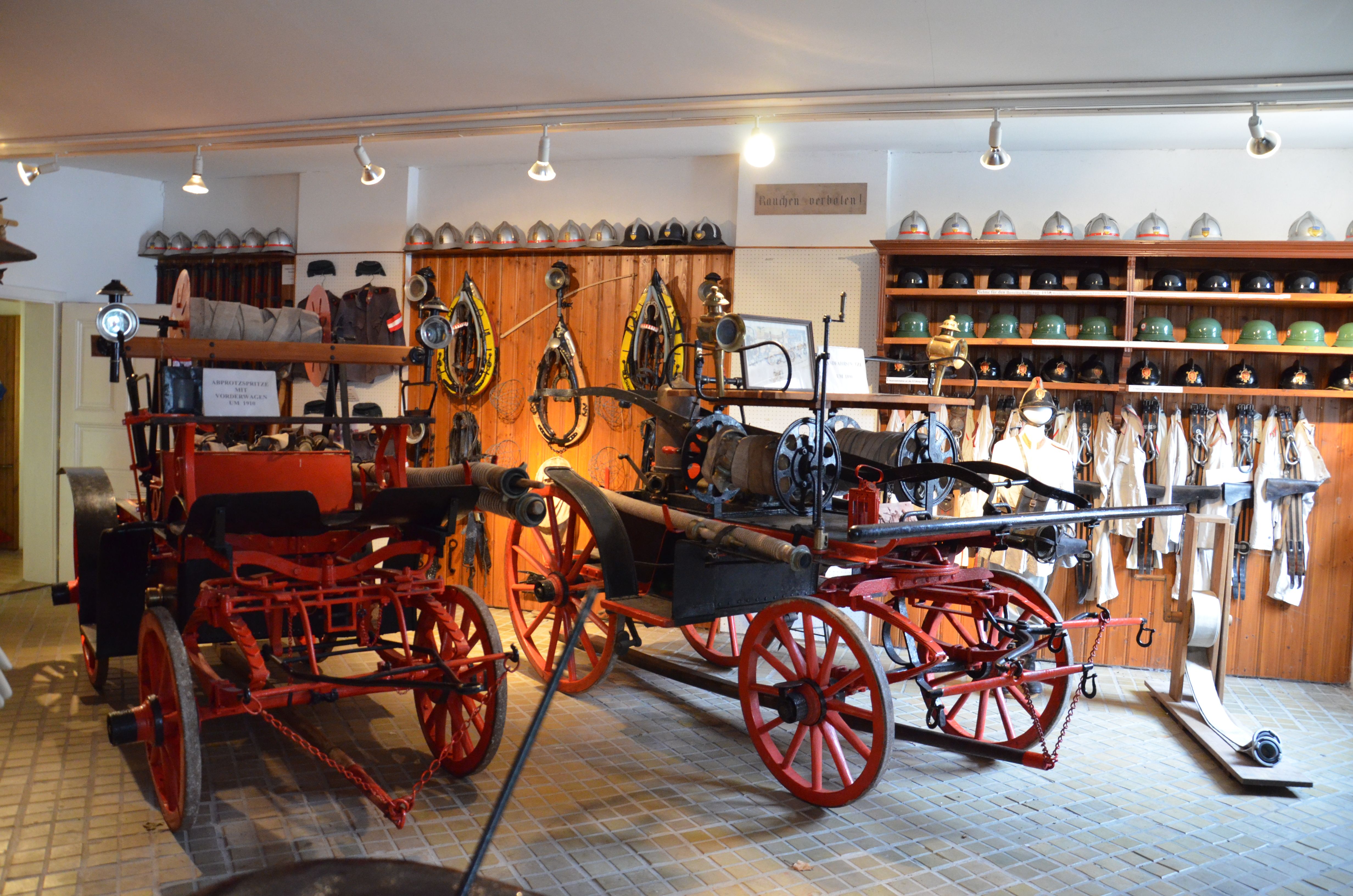 Innenansicht des Feuerwehrmuseums St. Leonhard am Forst mit alten Feuerwehrgeräten und Helmen.
