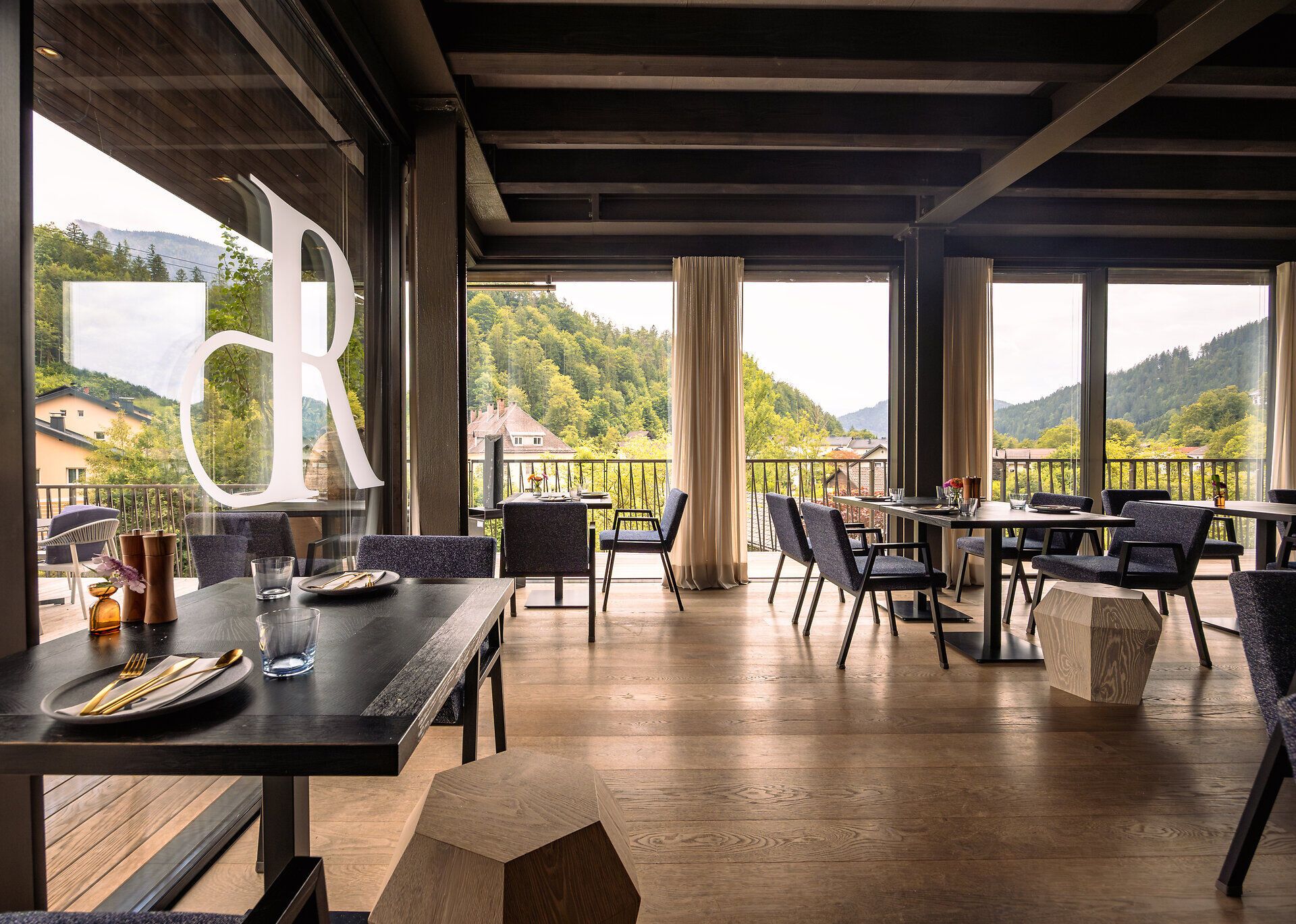 Inmitten der malerischen Landschaft des Mostviertels lädt das Refugium Lunz zu einer Auszeit ein. Die großen Fenster bieten einen atemberaubenden Blick auf die umliegenden Berge und das grüne Tal, während die stilvolle Einrichtung eine gemütliche Atmosphäre schafft. Hier können Besucher die Ruhe der Natur genießen und sich kulinarisch verwöhnen lassen.