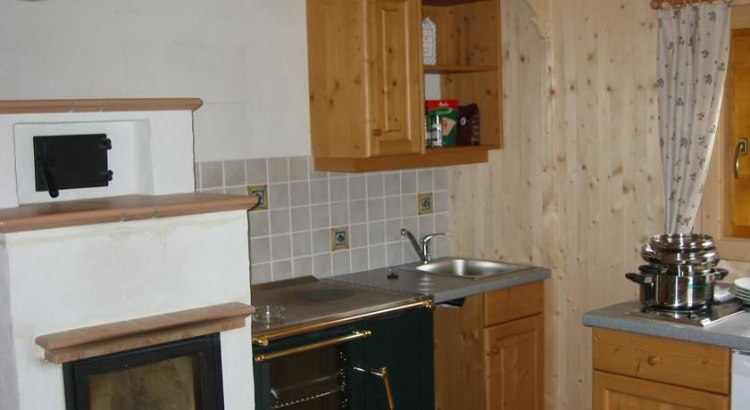 Küche in einem rustikalen Stil mit Holzschränken, einem Ofen und einem Herd.