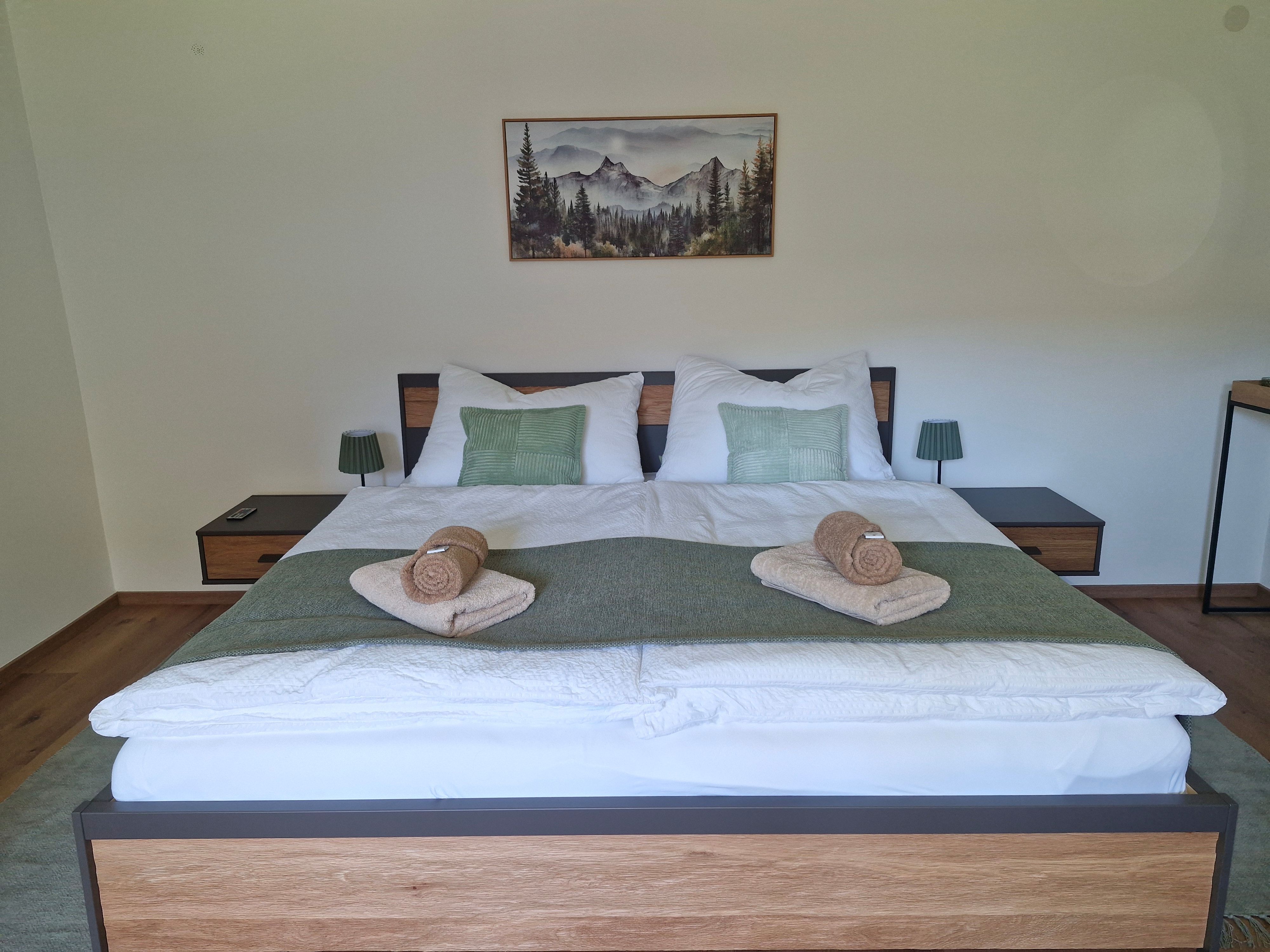 Doppelbettzimmer Aloisia dekoriert mit grünen Kissen und Handtüchern