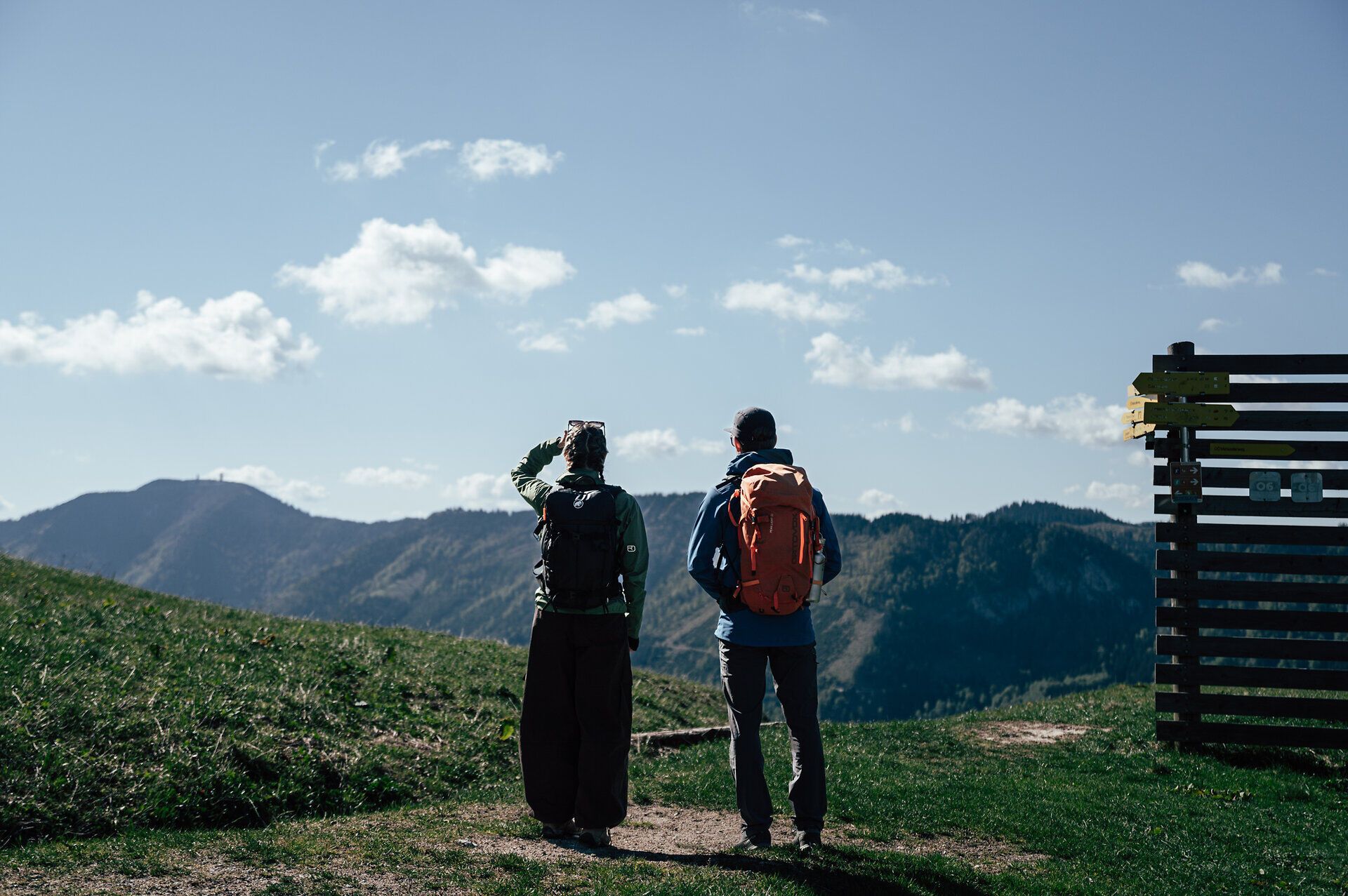 Zwei Wandernde blicken am Luchs Trail bei Wienerbruck auf die Berglandschaft des Ötschers.