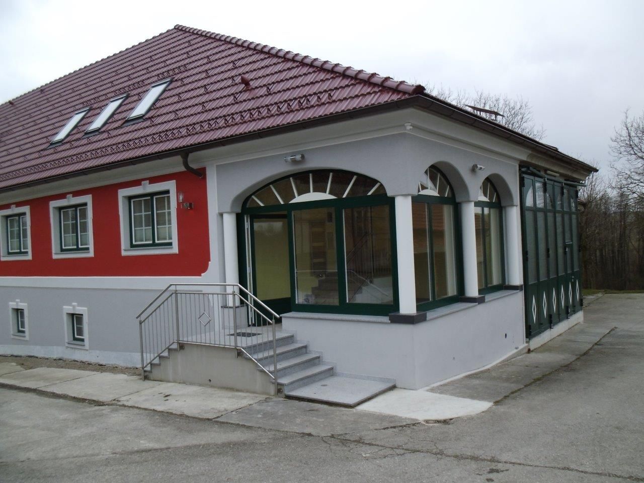 Ein modernes Gebäude mit rotem Dach und roter Fassade.
