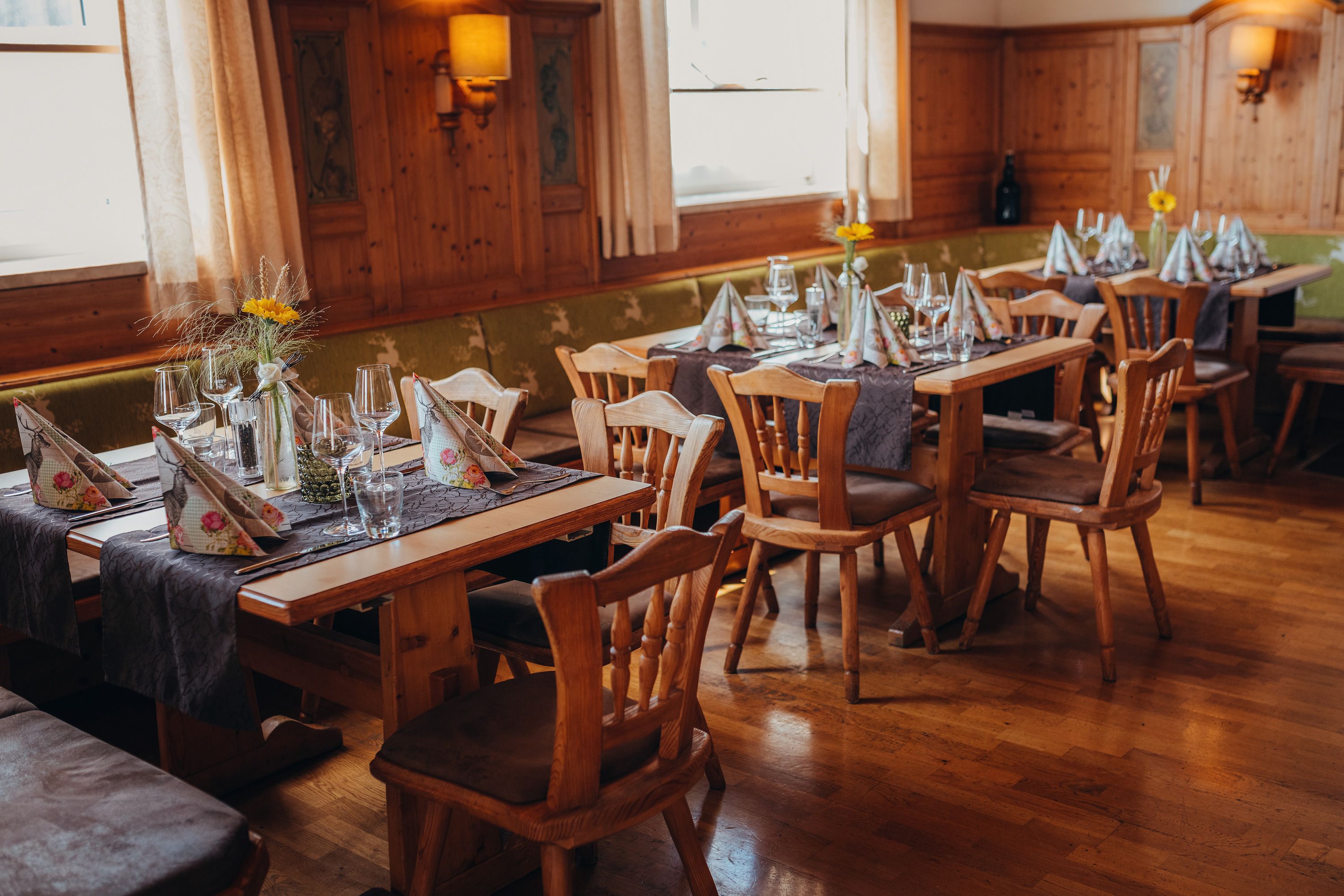 Gemütliches Restaurant mit Holzmöbeln und gedeckten Tischen.