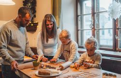 Familie backt gemeinsam Kekse auf dem Adventmarkt der Flammenden Weihnacht in Scheibbs. 
