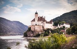 Blick auf Schloss Schönbühel, links fließt die Donau, recht erheben sich die Abhänge des Dunkelsteinerwaldes.