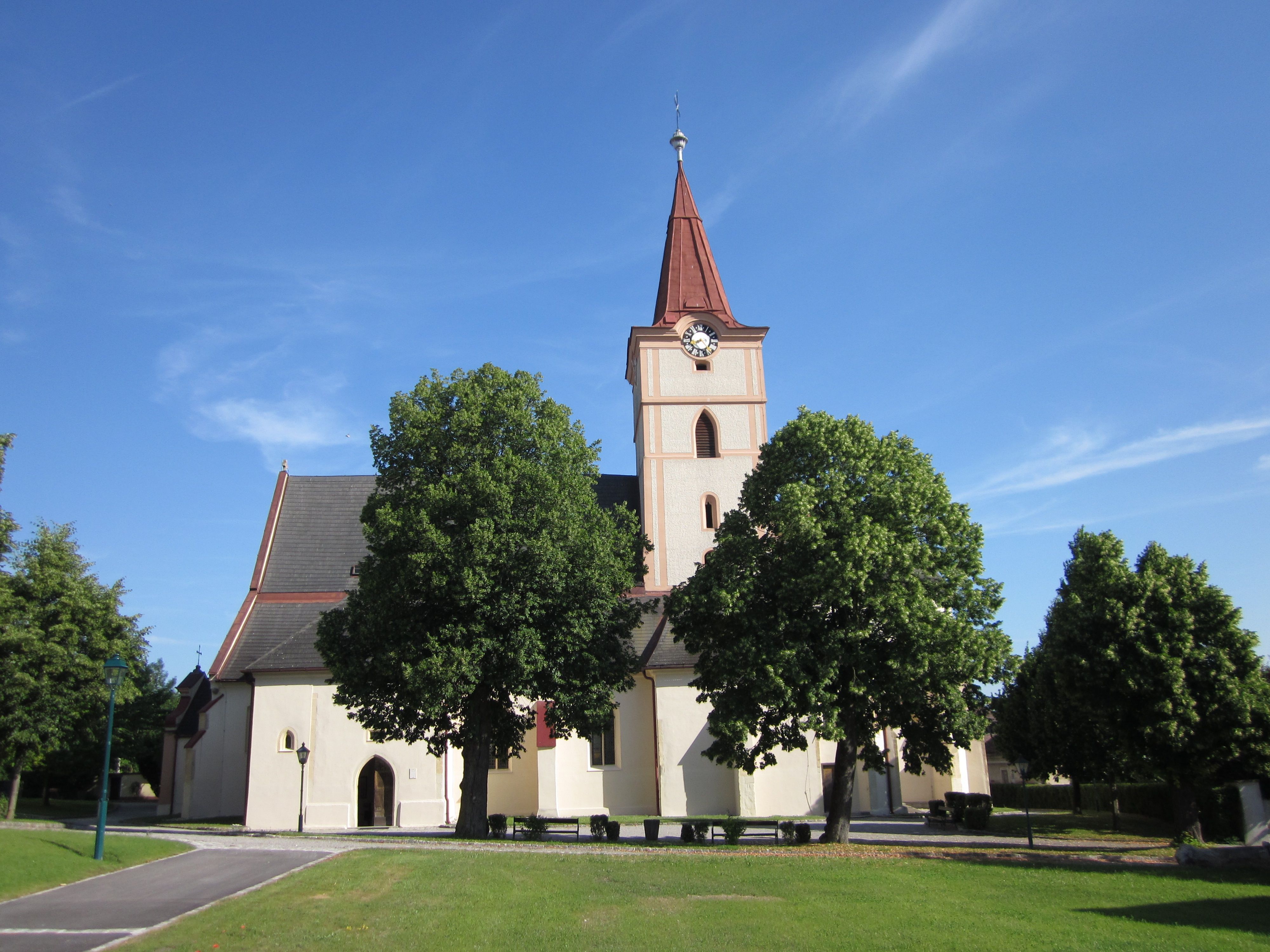 Pfarrkirche Pyhra mit Turm und Bäumen im Vordergrund.