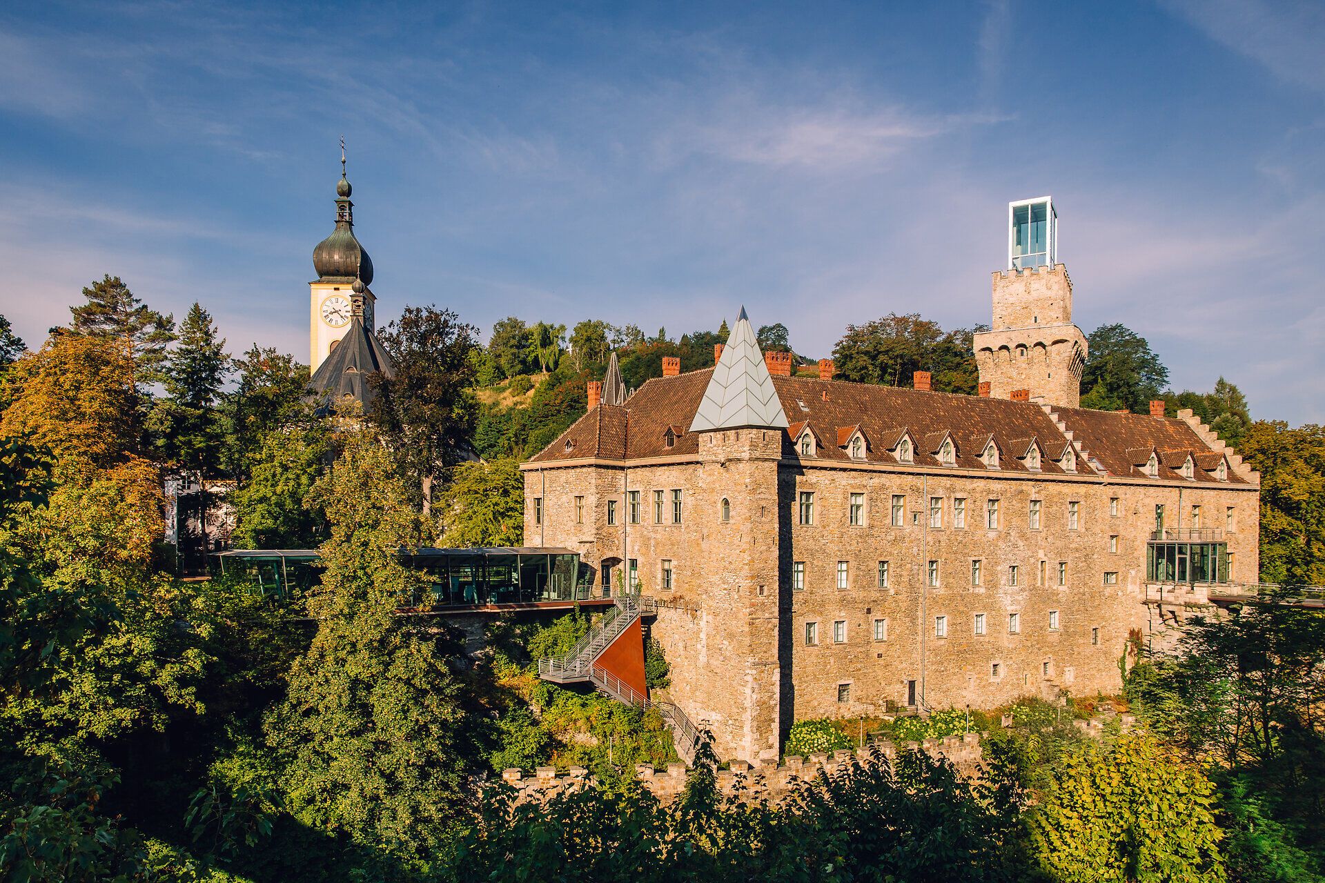 Schloss Rothschild in Waidhofen an der Ybbs mit historischem Gemäuer und Schlossturm inmitten grüner Landschaft.
