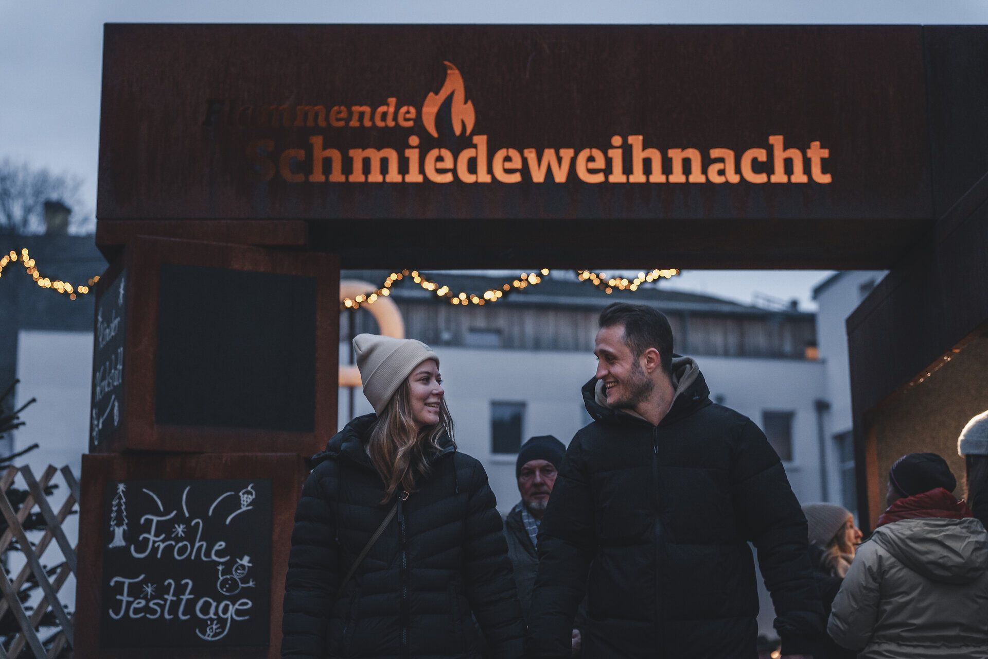 Ein Paar spaziert durch den stimmungsvollen Adventmarkt.