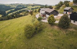 Eine Luftaufnahme, die die Lage des Almhauses Hochkogel in der offenen Hügellandschaft betont – weite Blicke über das Mostviertel und der Moststraße.